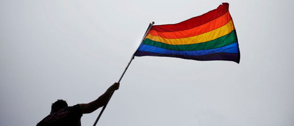 A man holds a flag as he takes part in an annual Gay Pride Parade in Toronto