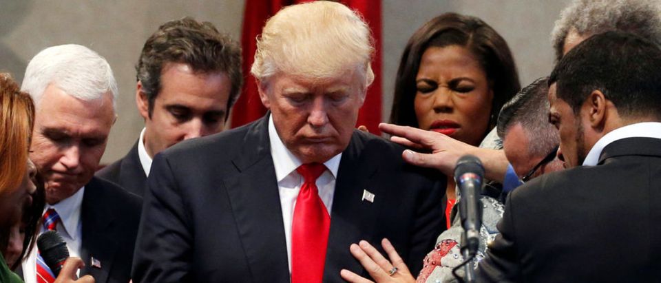 Members of the clergy lay hands and pray over Republican presidential nominee Donald Trump at the New Spirit Revival Center in Cleveland Heights