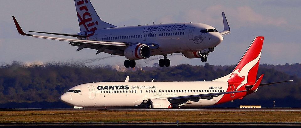 A Qantas Airways Boeing 737 plane sits on the tarmac as a Virgin Australia Boeing 737 plane lands at Sydney's Mascot Airport in Sydney, Australia July 6, 2017. REUTERS/David Gray - RTX3A8BT