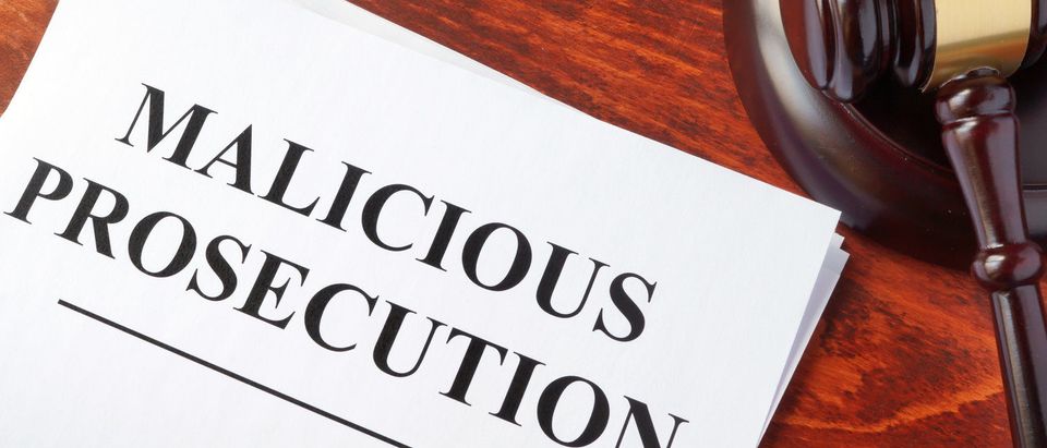 Malicious prosecution, documents and gavel on a table. (Shutterstock/designer491)
