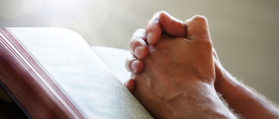 Hands folded in prayer on a Holy Bible in church concept for faith, spirtuality and religion (Brian A. Jackson/shutterstock_145450387)