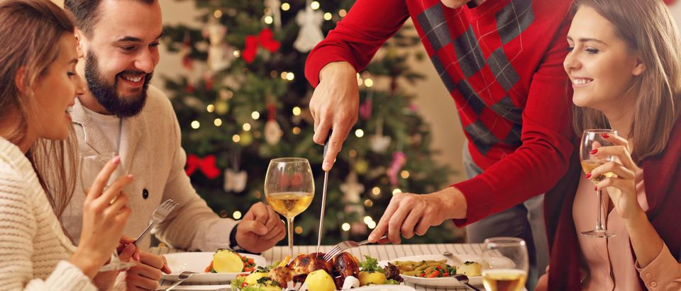 A family eats Christmas dinner. (Shutterstock/Kamil Macniack)