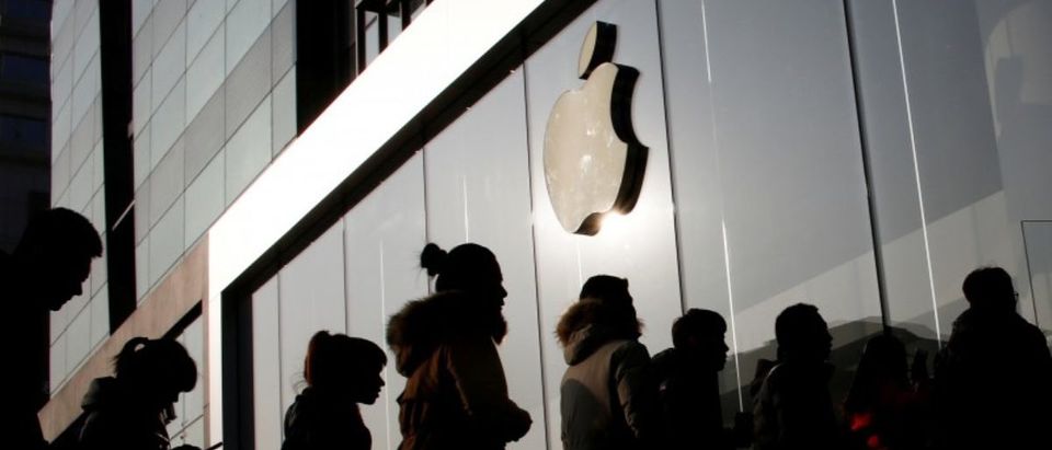 FILE PHOTO: People line up at an Apple store shortly before it opens in Beijing