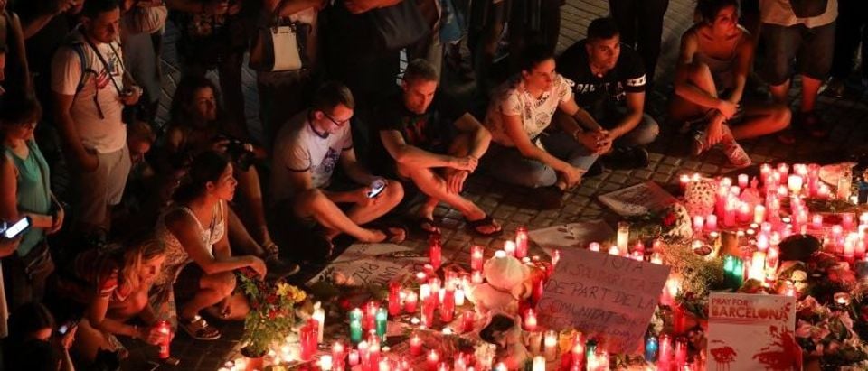 People gather around an impromptu memorial a day after a van crashed into pedestrians at Las Ramblas in Barcelona