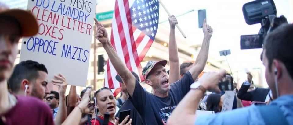 Pro Trump supporters face off with peace activists during protests outside a Donald Trump campaign rally in Phoenix