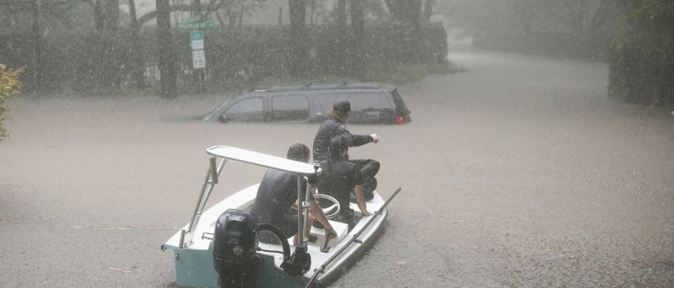 Volunteers and officers from the neighborhood security patrol help to rescue residents in the upscale River Oaks neighborhood (Scott Olson/Getty Images)