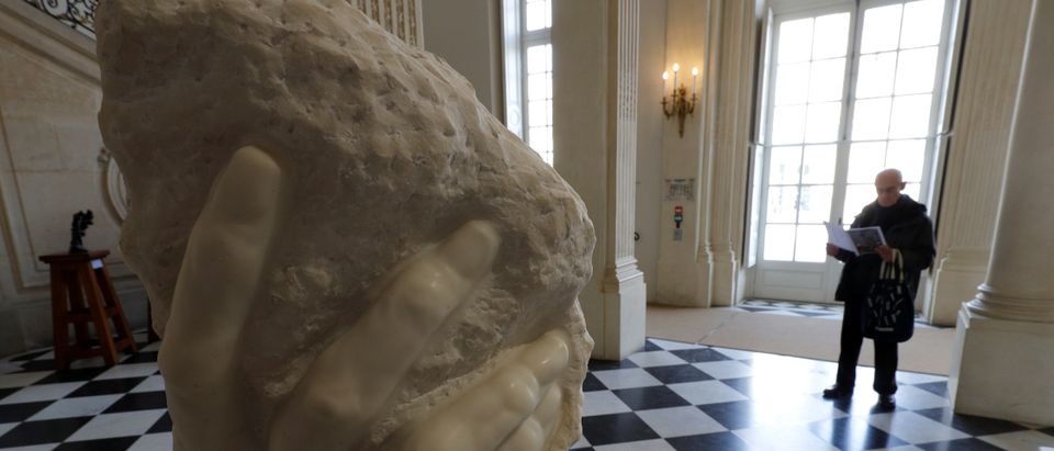 A visitor looks at the sculpture "The Hand of God, 1916-1918" by French sculptor Auguste Rodin (1840-1917) during an exhibition to celebrate the centenary of Auguste Rodin's death at the Musee Rodin in Paris