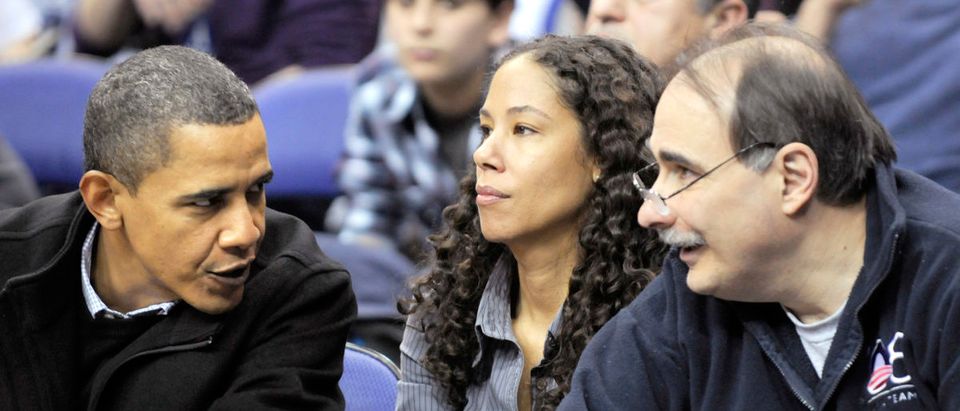 U.S. President Barack Obama (L) talks with Deputy White House Chief of Staff Mona Sutphen (C) and advisor David Axelrod at an NCAA basketball game between Georgetown University and Duke University in Washington January 30, 2010. REUTERS/Jonathan Ernst (UNITED STATES - Tags: POLITICS SPORT BASKETBALL)