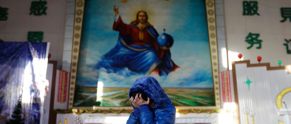 A student cries and covers her face with her hands after telling her Christmas story ahead of a mass at the Catholic church in Xiliulin village near the city of Taiyuan, Shanxi province, December 23, 2012. REUTERS/Jason Lee (CHINA - Tags: RELIGION SOCIETY) - RTR3BV0U