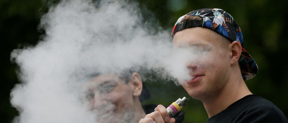 A man exhales electronic cigarette vapour in a park in central Kiev, Ukraine May 12, 2017. REUTERS/Valentyn Ogirenko