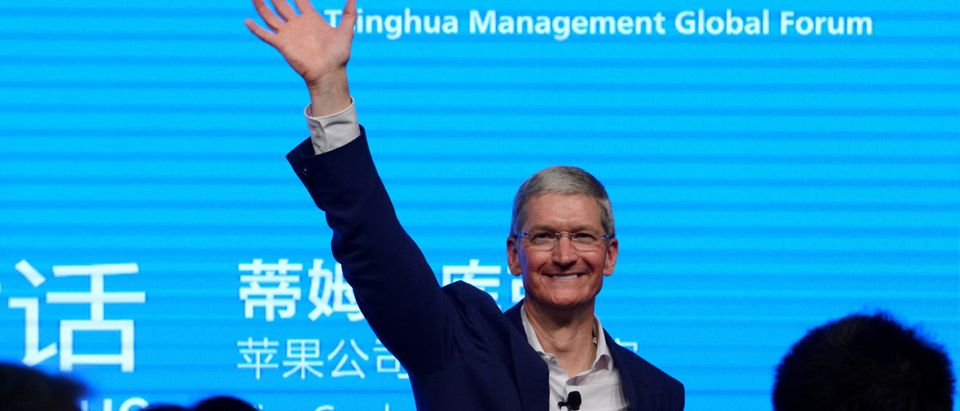 Apple CEO Tim Cook waves as he attends a talk in Beijing