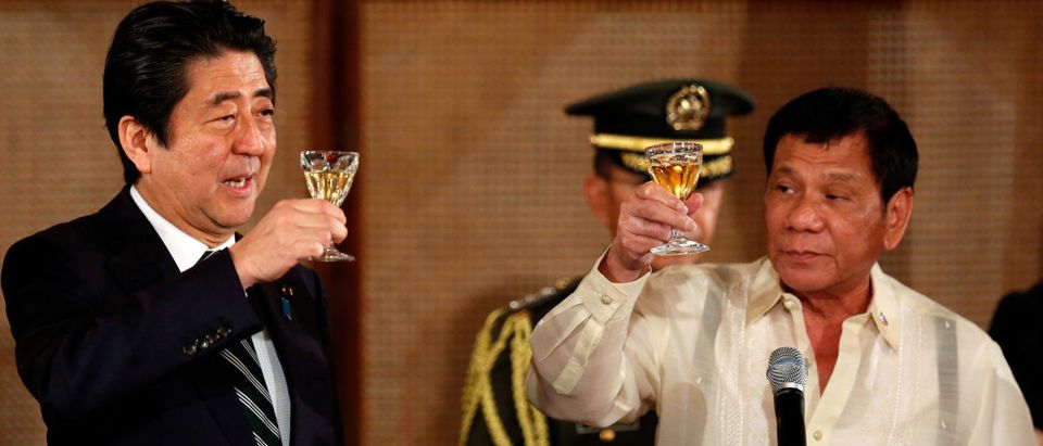 Philippine President Rodrigo Duterte and Japanese Prime Minister Shinzo Abe toast glasses during a state dinner at the Malacanang Presidential Palace in Manila