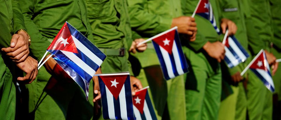 Army soldiers hold Cuban flags as they mark the 60th anniversary of the killing of Cuban revolutionary and student leader Jose Antonio Echeverria in Havana, Cuba, March 13, 2017. REUTERS/Alexandre Meneghini - RTX30UR1