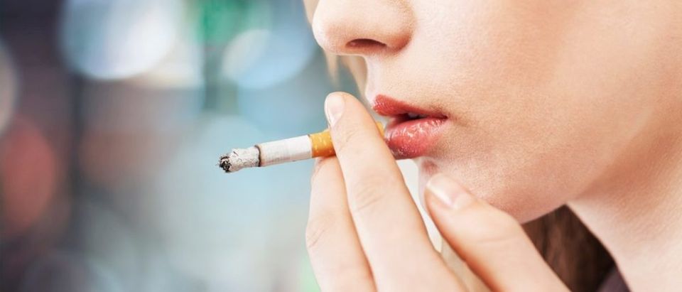 Woman smoking a cigarette (Photo via Shutterstock)