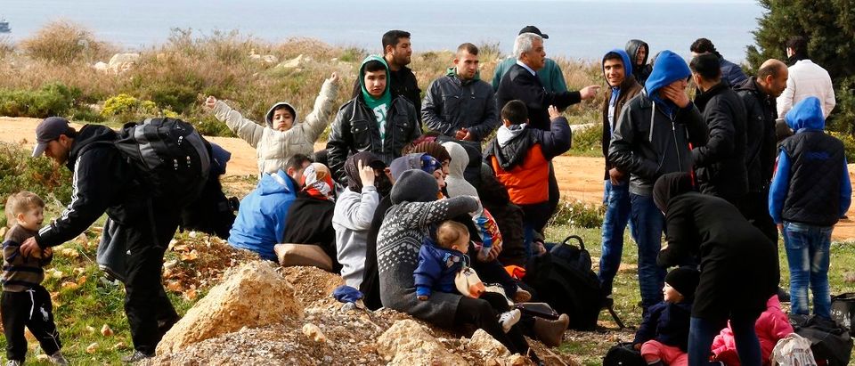 Syrian refugees wait on a roadside after Turkish police prevented them from sailing off to the Greek island of Farmakonisi by dinghies, near a beach in the western Turkish coastal town of Didim