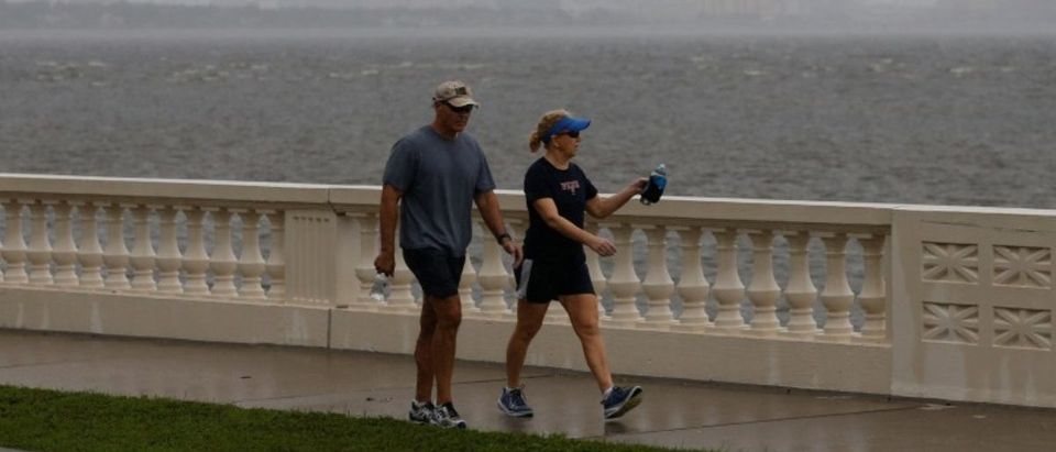 The Tampa skyline is seen in the background as people walk along Bayshore Boulevard ahead of the arrival of Hurricane Irma in Tampa, Florida, U.S., September 10, 2017. REUTERS/Chris Wattie