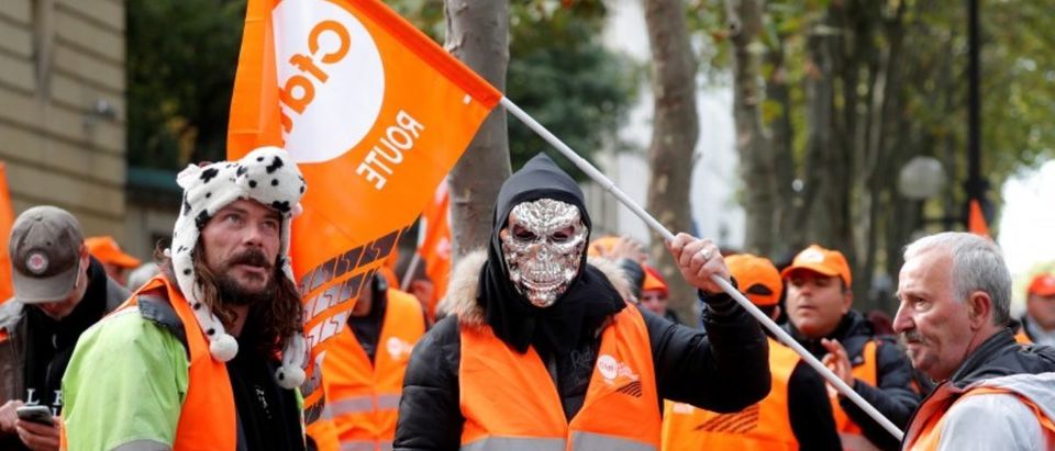 A masked demonstrator holds a flag of the French Democratic Confederation of Labour union (CFDT) in Paris during a national protest of lorry drivers against the government's labour reforms, France, September 18, 2017. REUTERS/Charles Platiau