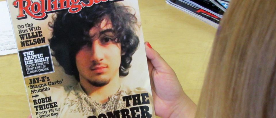 An early copy of Rolling Stone magazine's August 2013 issue is read at an office in Los Angeles on July 17, 2013. Rolling Stone defended the cover story on Boston bombing suspect Dzhokhar Tsarnaev, which triggered criticism that the magazine was "glamorizing terrorism" and calls to boycott the publication. At least two national chain stores announced they would not be selling the latest issue of the magazine, known for interviews with rock stars and others. The cover picture -- showing a goateed Tsarnaev, 19, was likened to a famous Rolling Stone cover portrait of the late singer Jim Morrison of "The Doors." The accompanying Rolling Stones article, titled "The Bomber," was described by the magazine as a "deeply reported account of the life and times" of Tsarnaev. The 12-page story is based on interviews with dozens of sources that "deliver a riveting and heartbreaking account of how a charming kid with a bright future became a monster," it said. AFP PHOTO/Michael THURSTON (Photo credit should read Michael THURSTON/AFP/Getty Images)
