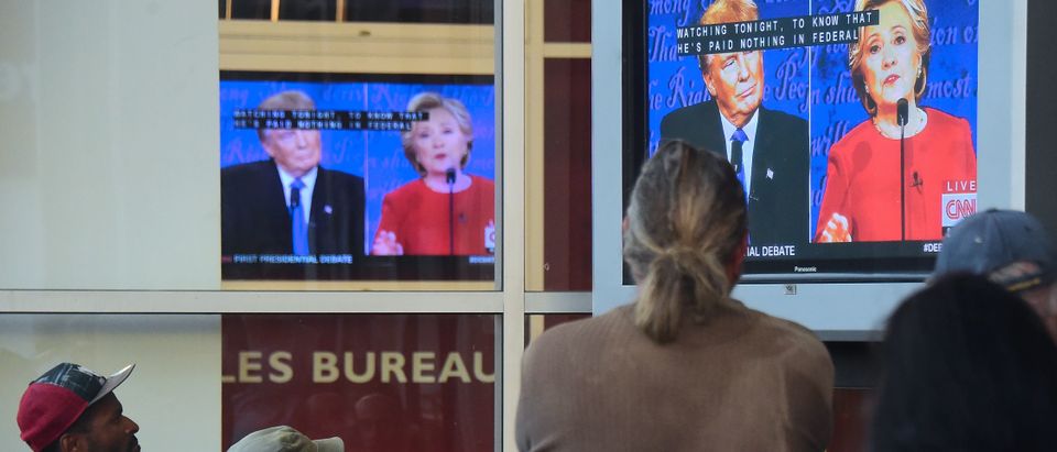 People gather to watch the first US presidential debate between Hillary Clinton and Donald Trump,nominees for the Democratic and Republican parties respectively, off a television set in front of an office building in Hollywood, California on September 26, 2016. FREDERIC J BROWN/AFP/Getty Images
