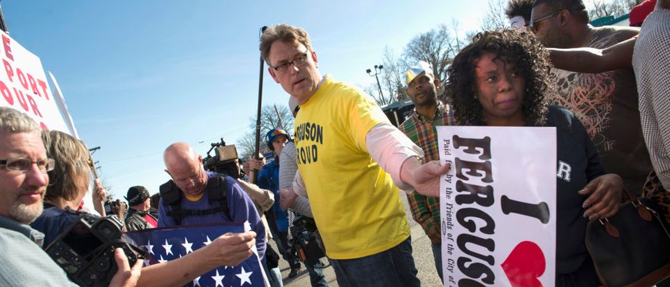 Ferguson resident, Blake Ashby, tries to separate Michael Brown supporters from Ferguson police supporters, outside the Ferguson Police Department and Municipal Court in Ferguson, Missouri, March 15, 2015. Ashby believes in transparency and reforming the Ferguson Police Department while supporting his community's police force. News of Sunday's arrest of suspect Jeffrey Williams in last week's shooting of two policemen during a protest rally in Ferguson, prompted a show of support for Ferguson's beleaguered police force. Williams, 20, has admitted to firing the shots that wounded the officers early on Thursday, said St. Louis County Prosecuting Attorney Robert McCulloch, and told investigators that he was not targeting police but was shooting at someone else. REUTERS/Kate Munsch