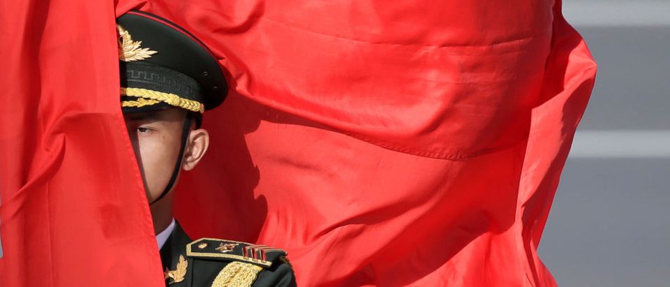 A soldier from honour guards holds a red flag during a welcoming ceremony in Beijing