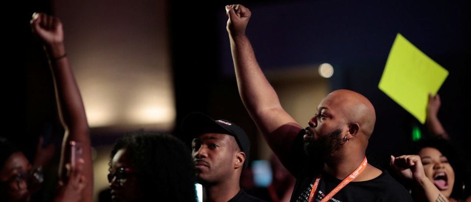 Ashton Woods (R), of Black Lives Matter:Houston, joins protesters as they disrupt a speech by Stacey Evans, who is running for governor of Georgia, at the morning plenary session at the Netroots Nation annual conference for political progressives in Atlanta, Georgia, U.S. August 12, 2017. REUTERS/Christopher Aluka Berry