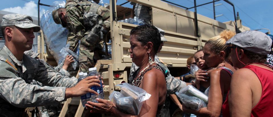 Soldiers of Puerto Rico's national guard distribute relief items to people, after the area was hit by Hurricane Maria in San Juan, Puerto Rico