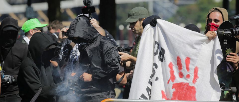 Antifa counter protesters against right-wing group Patriot Prayer light a smoke grenade in Portland, Oregon, U.S. Sept. 10, 2017. Patriot Prayer announced they were moving their Sunday rally from downtown Portland to nearby Vancouver, Washington, citing fears for their safety. REUTERS/Elijah Nouvelage