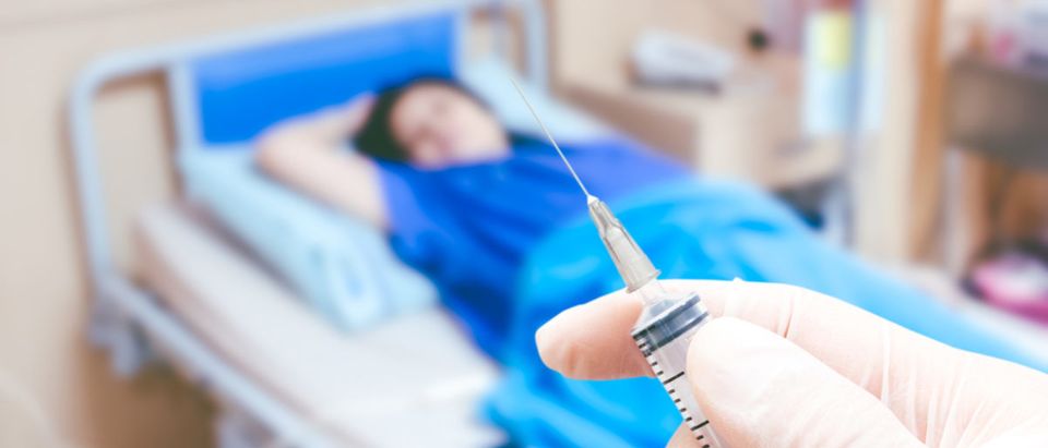 Medical syringe in the doctor's hands on the patient's in room hospital blur background (Art_Photo/shutterstock_398371651)