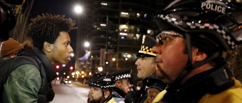 A demonstrator confronts police officers during protests in Chicago, Illinois