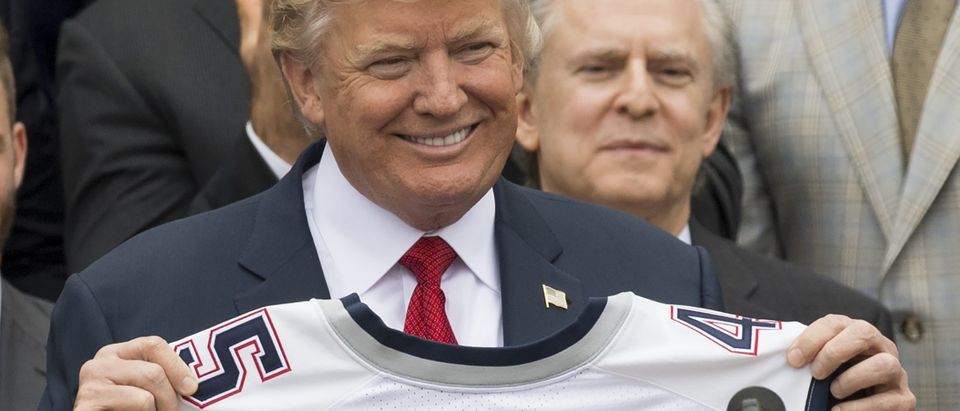 US President Donald Trump holds a jersey given to him by the New England Patriots alongside members of the team during a ceremony honoring them as 2017 Super Bowl Champions on the South Lawn of the White House in Washington, DC, April 19, 2017. SAUL LOEB/AFP/Getty Images