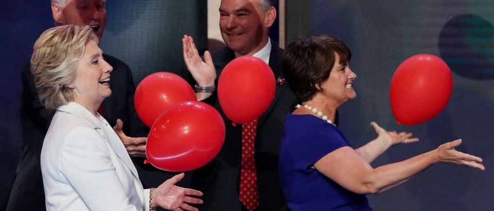 U.S. President Bill Clinton (L) and Hilllary Clinton's vice presidential running mate Tim Kaine look on as Democratic U.S. presidential nominee Hillary Clinton and Anne Holton, wife of Tim Kaine (R), bat ballons after Hillary Clinton accepted the nomination on the final night of the Democratic National Convention in Philadelphia, Pennsylvania, U.S. July 28, 2016. REUTERS/Mike Segar