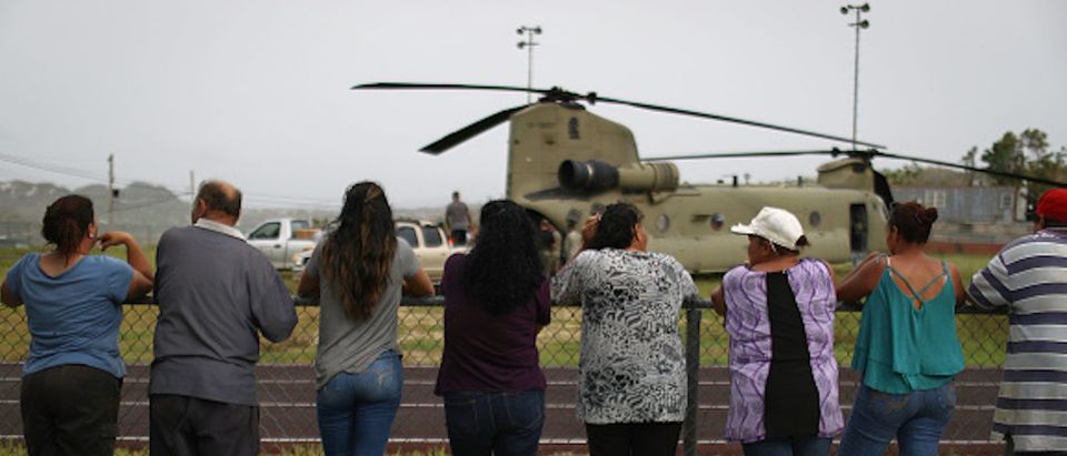 UTUADO, PUERTO RICO - OCTOBER 18: Local residents watch after a U.S. Army helicopter landed during food and water delivery efforts four weeks after Hurricane Maria struck on October 18, 2017 in Utuado, Puerto Rico. U.S. soldiers and agents delivered supplies provided by FEMA to remote residents in mountainous Utuado. Puerto Rico is suffering shortages of food and water in areas with only 19.10 percent of grid electricity restored. Puerto Rico experienced widespread damage including most of the electrical, gas and water grid as well as agriculture after Hurricane Maria, a category 4 hurricane, swept through. (Photo by Mario Tama/Getty Images)