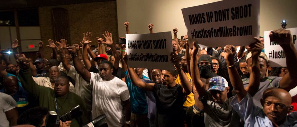 People raise their hands during a gathering to calm tension following the shooting death of black teenager Michael Brown at Greater St. Mark Family Church in St. Louis, Missouri August 12, 2014. Police said Brown, 18, was shot in a struggle with a gun in a police car but have not said why Brown was in the car. At least one shot was fired during the struggle and then the officer fired more shots before leaving the car, police said. But a witness to the shooting interviewed on local media has said that Brown had been putting his hands up to surrender when he was killed. The FBI has opened a civil rights investigation into the racially charged case and St. Louis County also is investigating. REUTERS/Mario Anzuoni