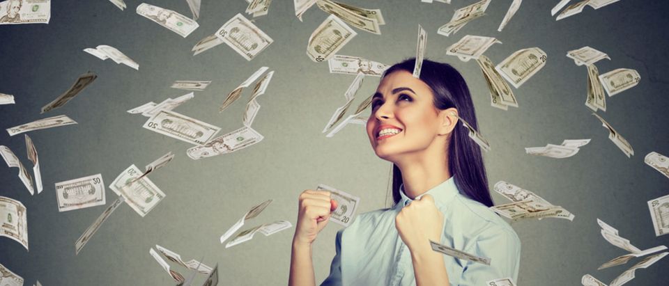 A woman celebrates her sudden wealth. (Shutterstock/pathdoc)