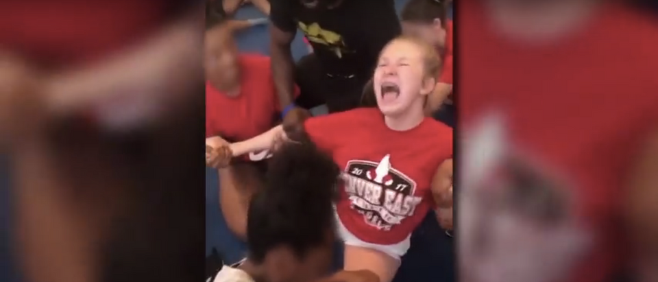 A cheerleader is forced to perform the splits (Screenshot/Youtube/9News)