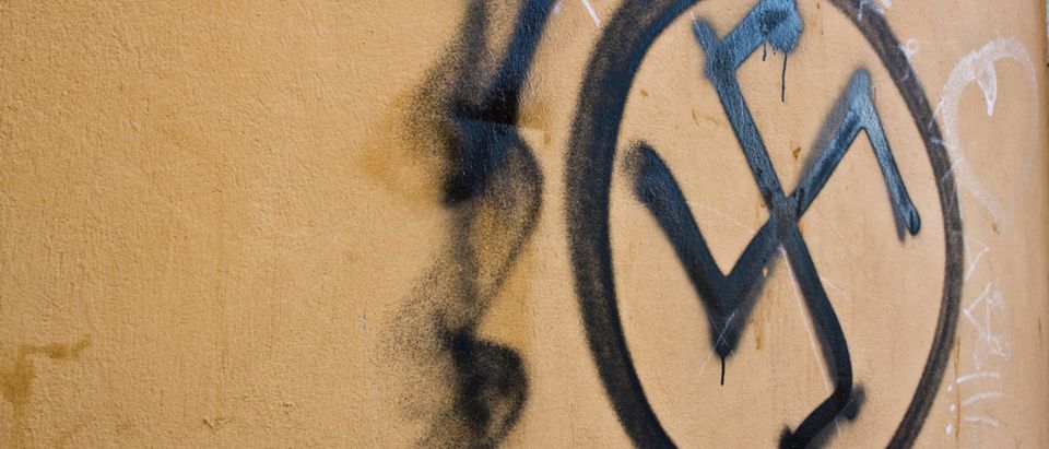 Swastika spray-painted on a wall. [Shutterstock - Minerva Studio]