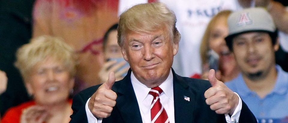 U.S. President Donald Trump gives a thumbs up to supporters at the Phoenix Convention Center during a rally on August 22, 2017 in Phoenix, Arizona. An earlier statement by the president that he was considering a pardon for Joe Arpaio,, the former sheriff of Maricopa County who was convicted of criminal contempt of court for defying a court order in a case involving racial profiling, has angered Latinos and immigrant rights advocates. Ralph Freso/Getty Images.
