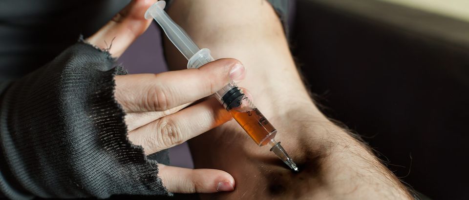 Addict hands making a syringe injection of heroin are shown here. (Shutterstock/Nomad_Soul)