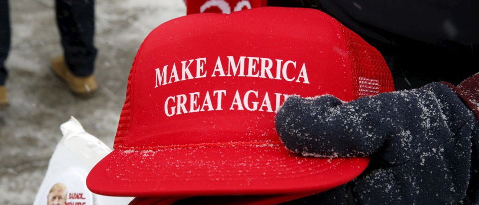 Trump campaign merchandise vendor David Dickson from Florida holds Trump campaign "Make America Great Again" hats dusted with falling snow outside a Trump campaign town hall event in Londonderry, New Hampshire February 8, 2016. REUTERS/Jim Bourg