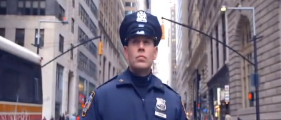 An NYPD police officer stands ready for action (Photo Credit: YouTube/NYPD)
