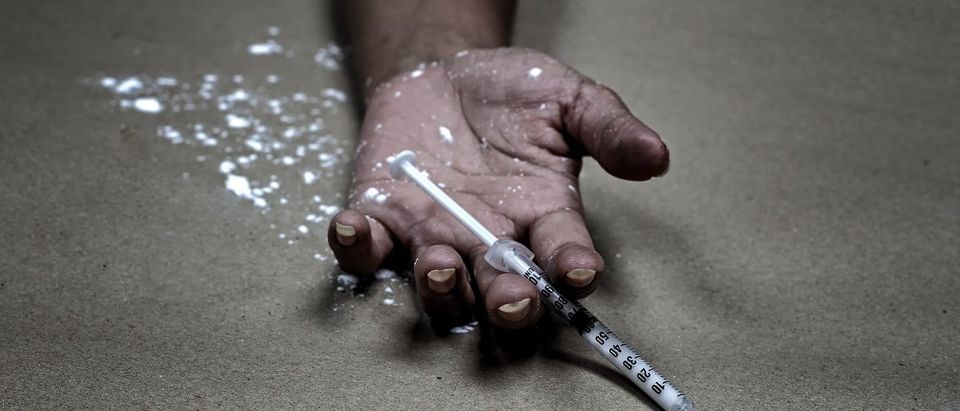 Drug abuse concept., overdose asian female drug addict hand, drugs narcotic syringe in hand on the floor. (Photo: Shutterstock/SanchaiRat)