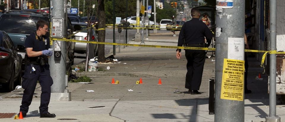 Police place evidence markers at spots where shell casings have been found at the scene of a shooting at the intersection of West North Avenue and Druid Hill Avenue in West Baltimore, Maryland May 30, 2015. Local media have reported more than 35 murders in the city of Baltimore since the April rioting over the death of 25-year-old resident Freddie Gray and shootings continue regularly in his West Baltimore neighborhood. REUTERS/Jim Bourg