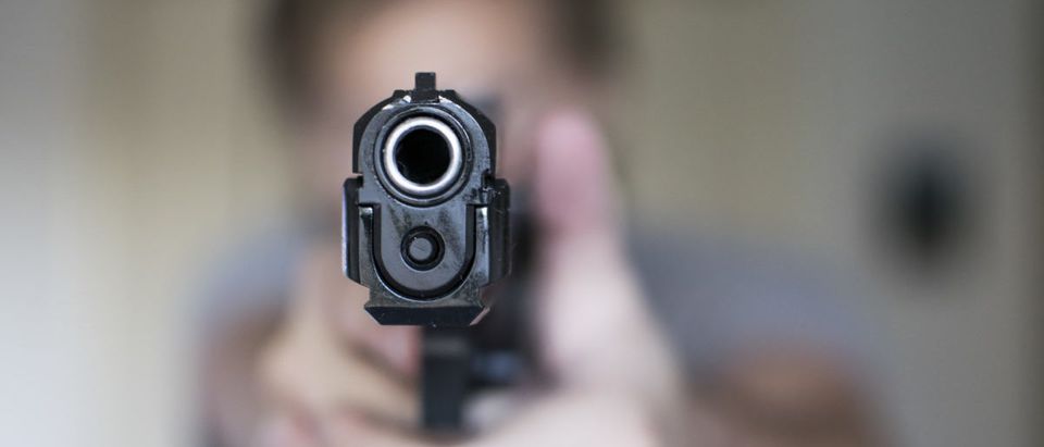 Man holding gun in self defense (ShutterStock/Seth Ryan)