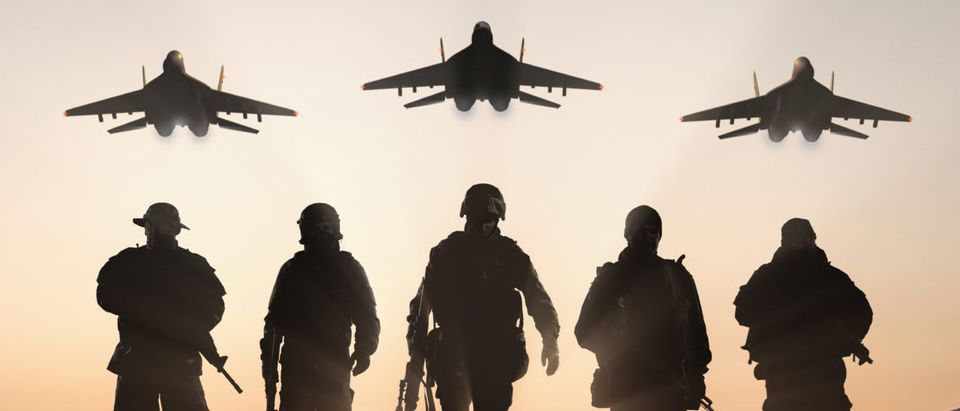 Military silhouettes of soldiers and airforce against the backdrop of sunset sky. (ShutterStock/BPTU)