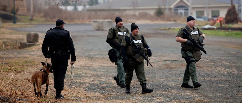 Police SWAT officers and a K-9 team search for Bradley William Stone, 35, an Iraq war veteran suspected of fatally shooting and stabbing six family members in Pennsburg, Pennsylvania December 16, 2014. The search for Stone was focused around his hometown of Pennsburg, about 50 miles (80 km) northwest of Philadelphia, where residents were advised to stay inside with their doors locked, Montgomery County District Attorney Risa Vetri Ferman told a news conference. REUTERS/Brad Larrison
