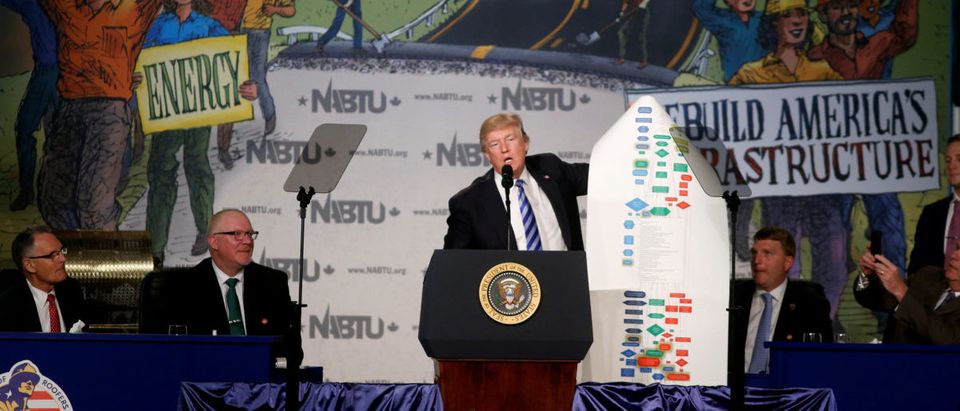 U.S. President Donald Trump holds up a chart showing the complexity of regulations as he speaks at the 2017 North Americas Building Trades Unions National Legislative Conference in Washington