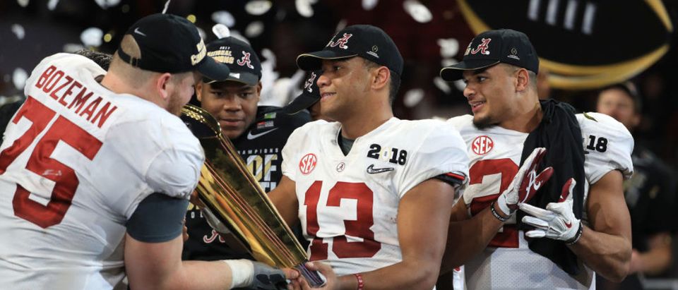 Tua Tagovailoa #13 of the Alabama Crimson Tide holds the trophy while celebrating with his team after defeating the Georgia Bulldogs in overtime to win the CFP National Championship presented by AT&T at Mercedes-Benz Stadium on January 8, 2018 in Atlanta. (Photo by Mike Ehrmann/Getty Images)