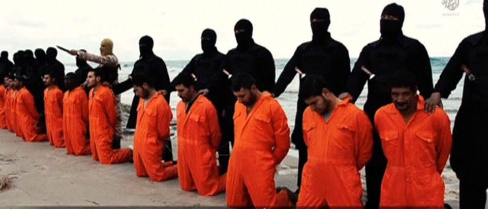 Still image from video shows men purported to be Egyptian Christians held captive by the Islamic State kneeling in front of armed men along a beach said to be near Tripoli