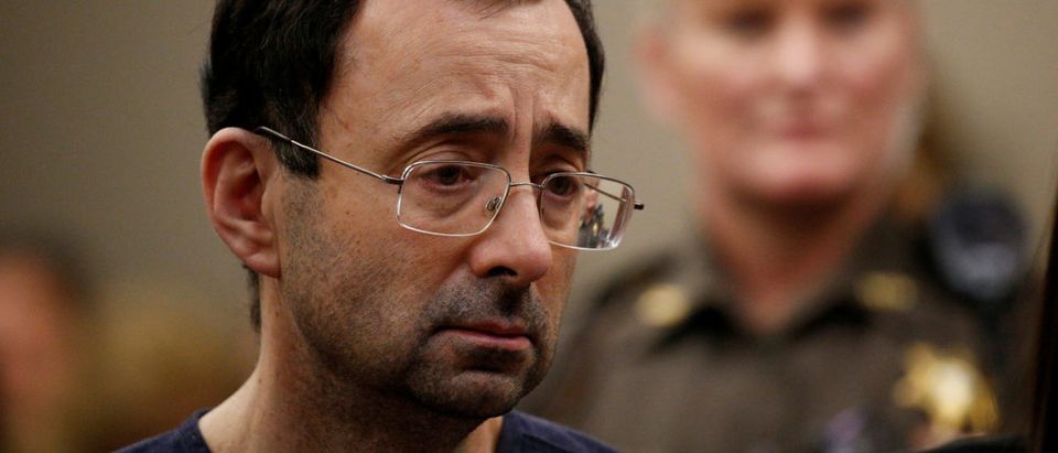 FILE PHOTO: Larry Nassar, a former team USA Gymnastics doctor who pleaded guilty in November 2017 to sexual assault charges, stands with his legal team during his sentencing hearing in Lansing